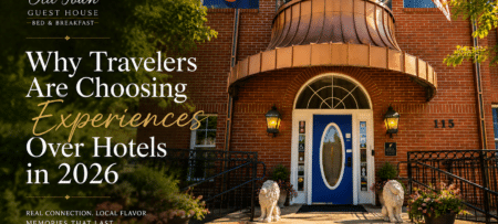Hero image for Old Town Guest House: brick inn entrance with blue door, flags, and oversized headline about 'Why Travelers Are Choosing Experiences Over Hotels in 2026' on the left side.