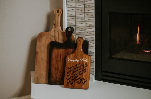 Three wooden kitchen paddles next to a gas fireplace.
