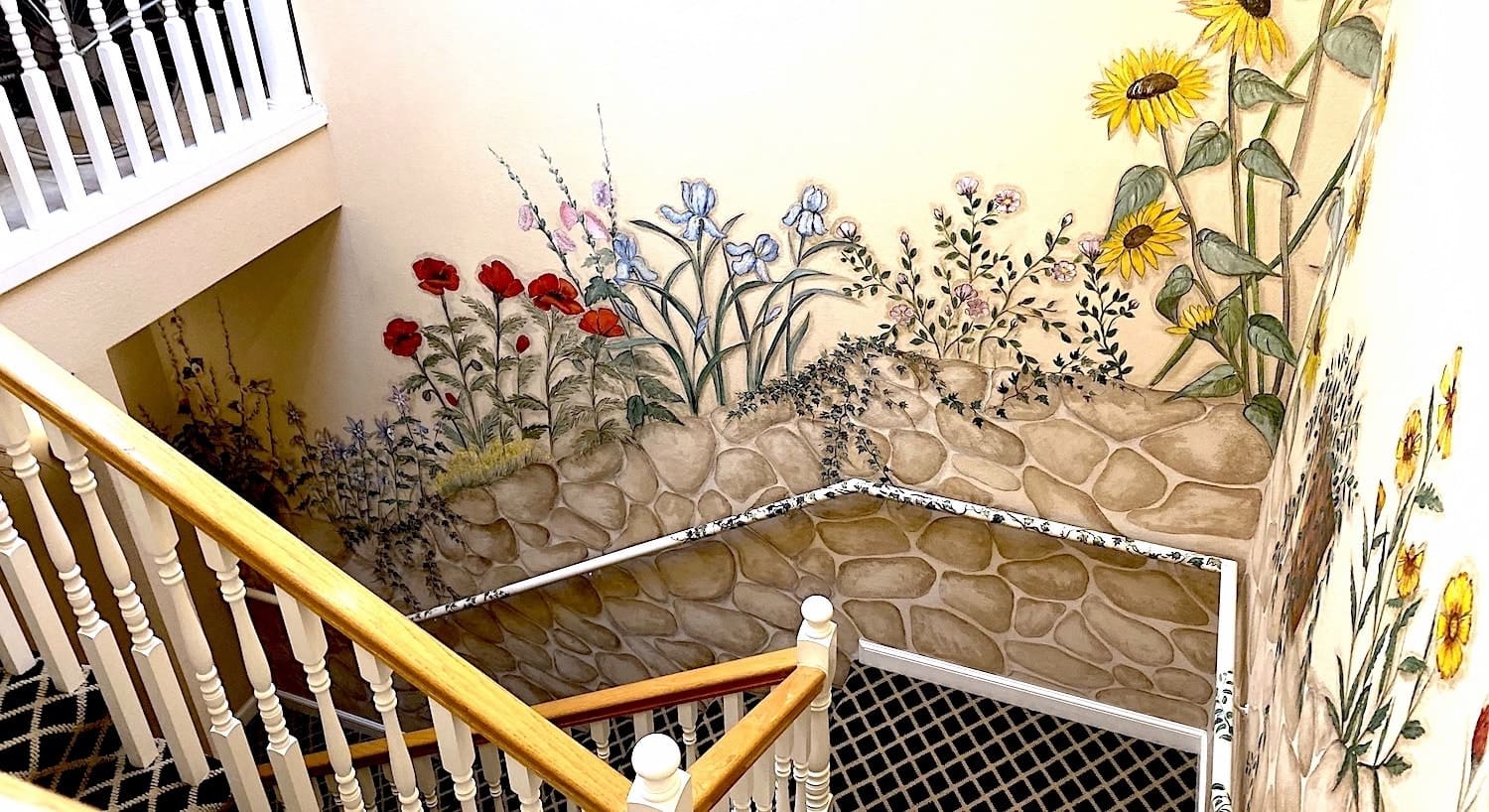 Stairwell with handpainted stones and flowers on the wall