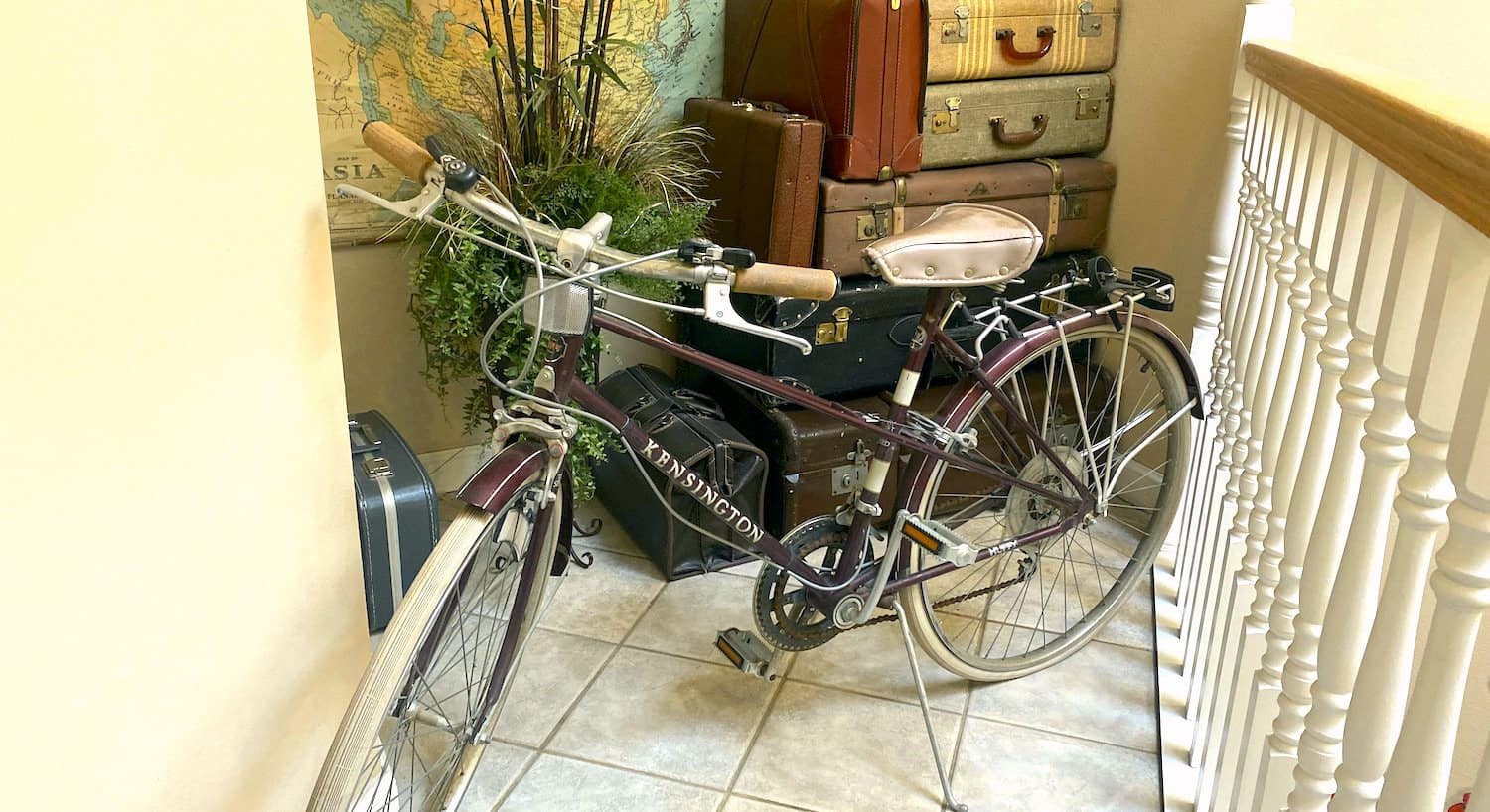 Close up view of antique bicycle in front of multiple antique suitcases