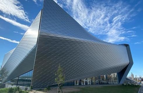 Artistic shaped silver building with blue sky in the background