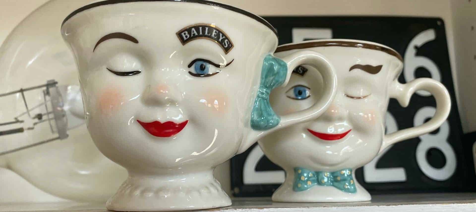 Close up view of handpainted teacups shaped as winking girl and boy faces